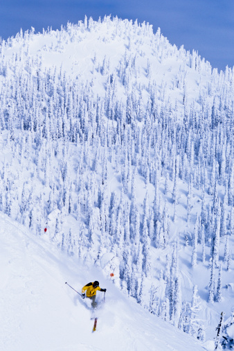 Skier with big turn below peak. photo