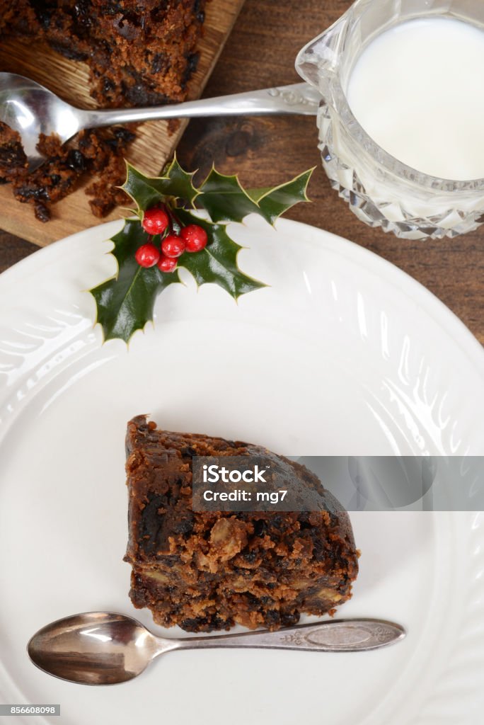 top view christmas pudding with spoon top view christmas pudding with spoon on white plate Berry Stock Photo