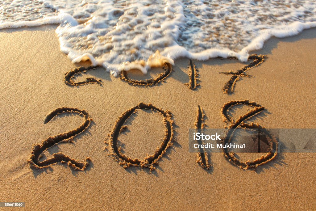 2018 year written on sandy beach sea. Inscription 2017 washes off wave. 2017 Stock Photo