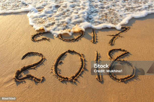 2018 Year Written On Sandy Beach Sea Inscription 2017 Washes Off Wave Stock Photo - Download Image Now