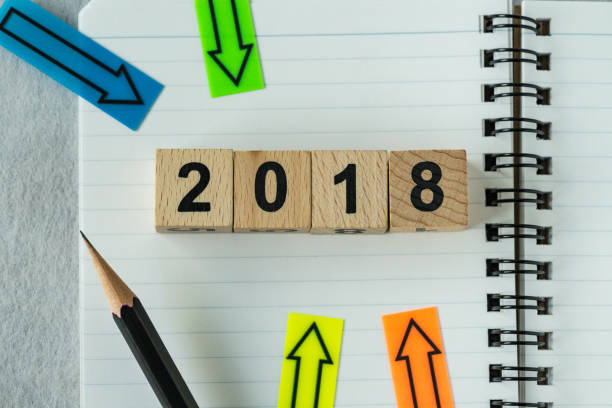 istock selective focus on wooden cube block 2018 with arrows pad on note paper as new year 2018 aim or goals concept 856611192