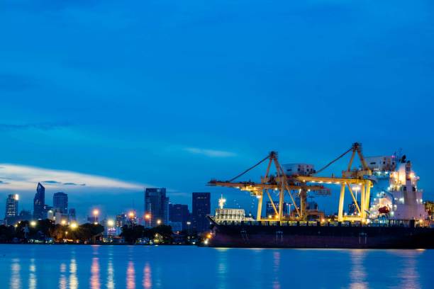 istock Container loading by crane, cargo ship at shipping port at twilight, Logistics and transportation concept 856612070