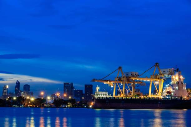 istock Container loading by crane, cargo ship at shipping port at twilight, Logistics and transportation concept 856612106