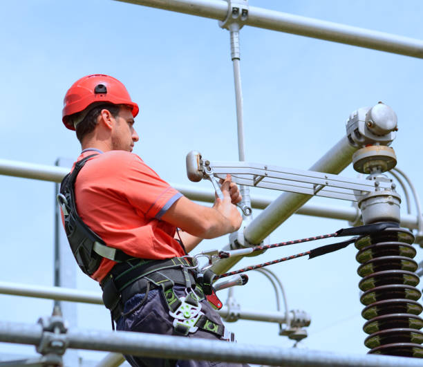istock Electrician with protective workwear, hardhat and safety harness working 856614372
