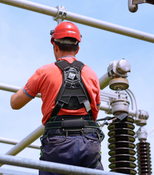 istock Electrician with protective workwear, hardhat and safety harness working 856614520