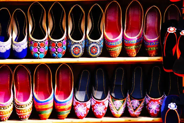 Handmade shoes on the flea market in Mumbai. Indian bazaar. Colorful shoes. Pattern, background.