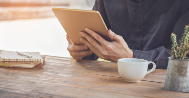 istock Close up businessman using tablet working in coffee shop. 856617862
