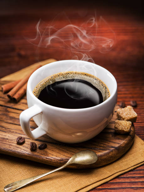 istock Cup of coffee and cane sugar cubes on wooden table. 856623686