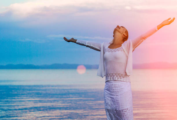 istock Cheering woman open arms under sunrise on beach 856628404