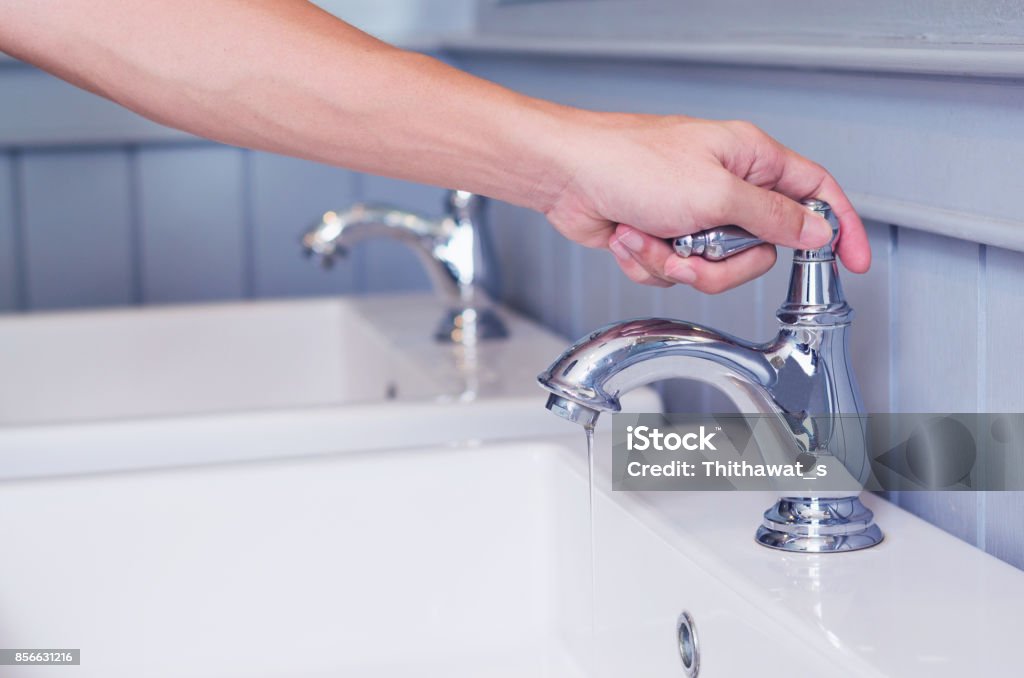 homme argent robinet robinet ou l’eau d’ouverture avec évier de lavage dans des toilettes publiques de blanc à la main. - Photo de Robinet libre de droits