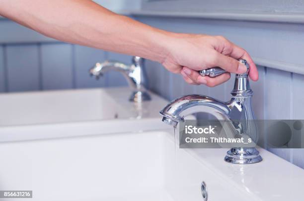 Photo libre de droit de Homme Argent Robinet Robinet Ou Leau Douverture Avec Évier De Lavage Dans Des Toilettes Publiques De Blanc À La Main banque d'images et plus d'images libres de droit de Robinet