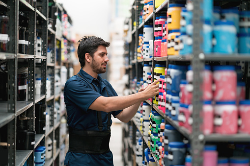 Latin American man working at a warehouse organizing products on the shelves - business concepts
