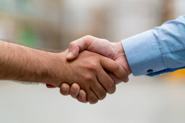 istock Men at a warehouse closing a deal with a handshake 856634896