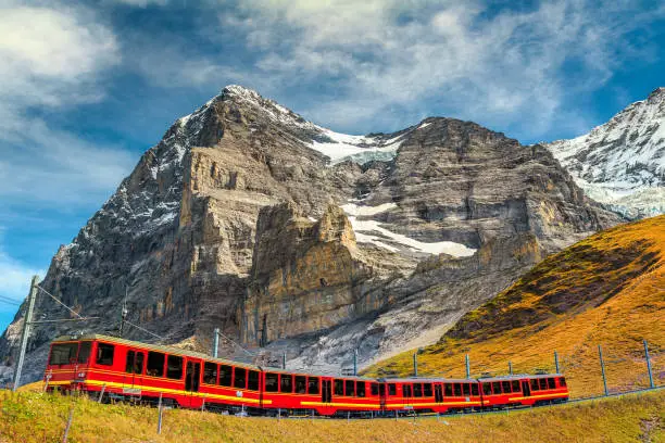 Famous express electric red tourist train coming down from the Jungfraujoch station(top of Europe) in Kleine Scheidegg tourist station, Bernese Oberland, Switzerland, Europe