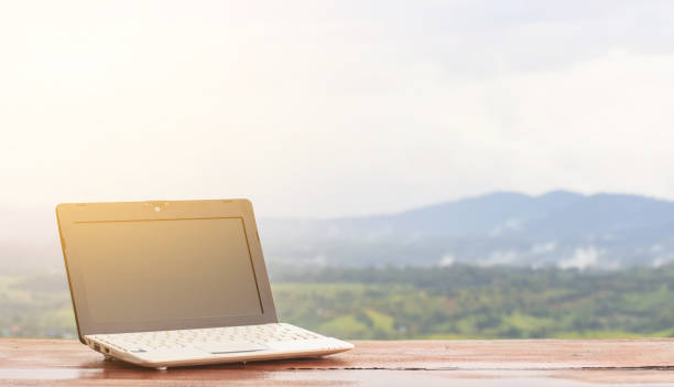 istock Laptop stands on a wooden table outdoors and nature background 856642606