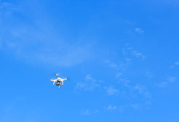 istock Flying drone with blue sky background controlled by professional photographer 856642608