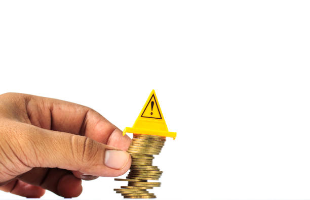 istock Unstable pile of coins and Warning label on whitebackground-Financial risk concept 856642728