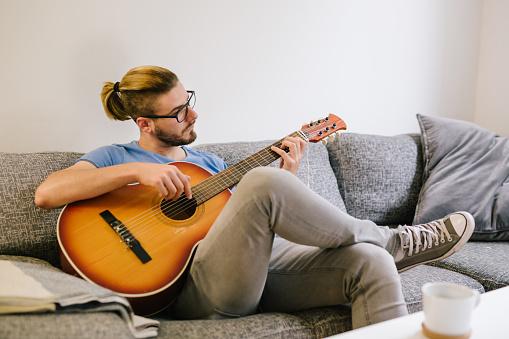 Man playing guitar at home