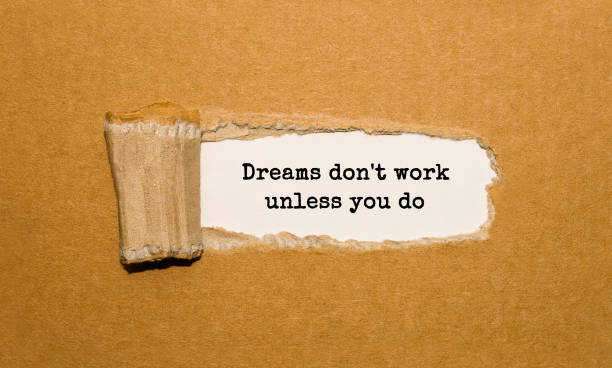 istock The text Dreams don't work unless you do appearing behind torn brown paper 856655876