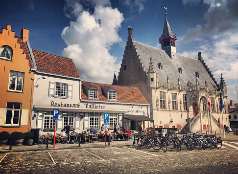 Damme, Belgium - September 19, 2017: Main square in Damme with restaurant, bicycles parked on the street and people enjoying food and sunny day.