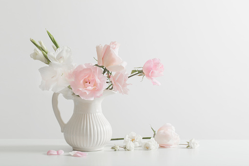 pink and white flowers in vase on white background