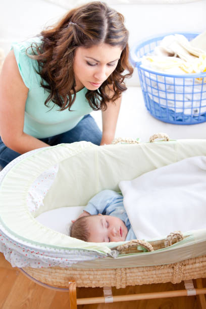 istock Young mother looking at her little son sleeping in his bed 856669008