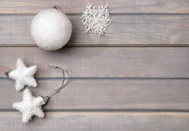 istock Christmas ornaments in white on a light gray wooden background. View from above. Space for text. 856672032