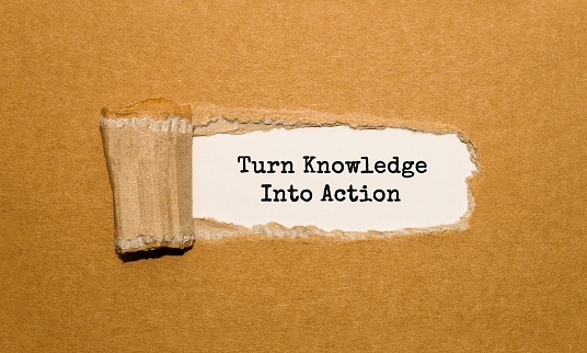 The text Turn Knowledge Into Action appearing behind torn brown paper