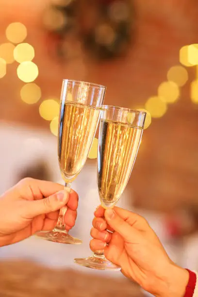 Photo of Two glasses of champagne over blur lights background.