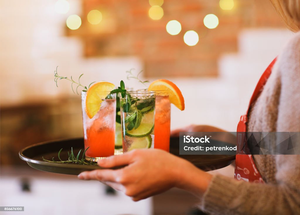 Young pretty woman with red and green cocktails on tray Young pretty woman with red and green cocktails on tray in the bar Drink Stock Photo