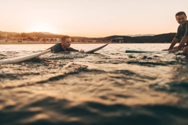 istock Friends surfing in the ocean 856679732