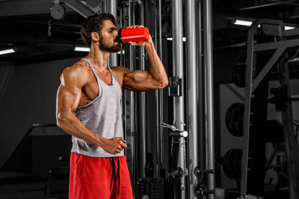 gli uomini muscolosi bevono il suo integratore alimentare - abdominal muscle muscular build barbell bicep foto e immagini stock