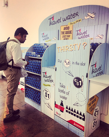 Brussels, Belgium - September 23, 2017:  Travel Water for passengers inside Brussels Airport. Man buying water before flight
