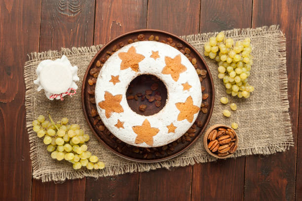 gâteau aux fruits traditionnel maison sur plaque d’argile orné de raisins, noix et miel pot à la vue de dessus de table en bois - fruitcake christmas cake cake raisin photos et images de collection