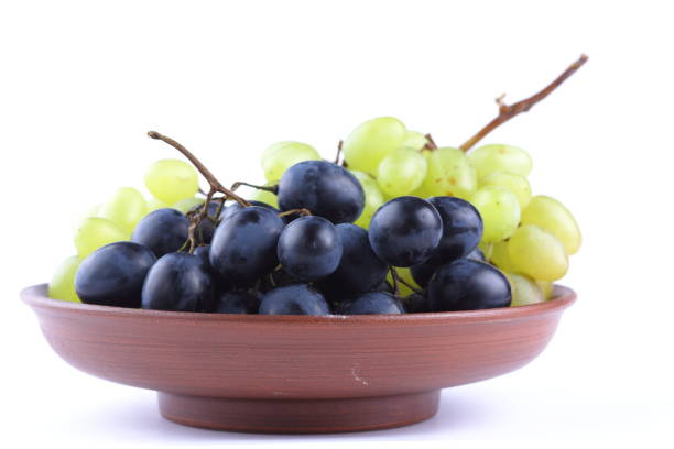 istock Green and blue grapes in a clay plate on a white background 856702818