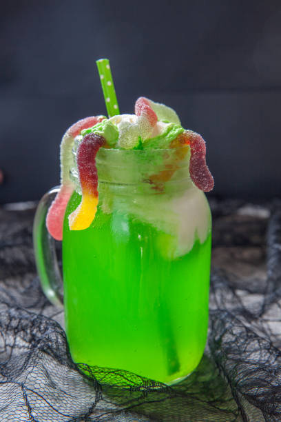grün-drink mit eis schweben und gummibärchen würmer für halloween - glass autumn halloween food stock-fotos und bilder