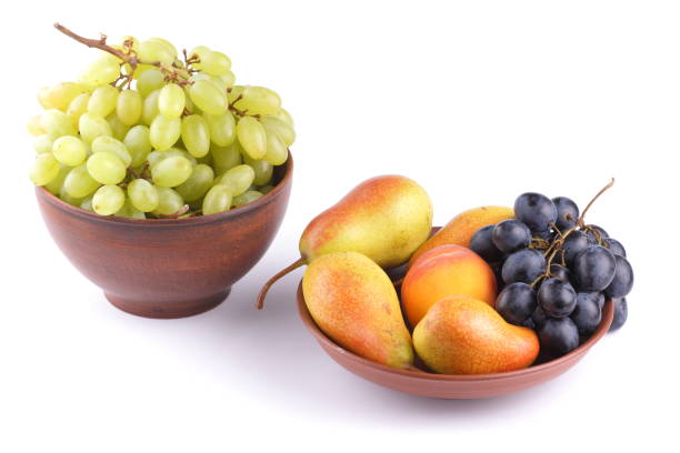 istock Yellow pears, green and blue grapes in a clay plate on a white background 856706928