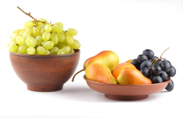 istock Yellow pears, green and blue grapes in a clay plate on a white background 856706944