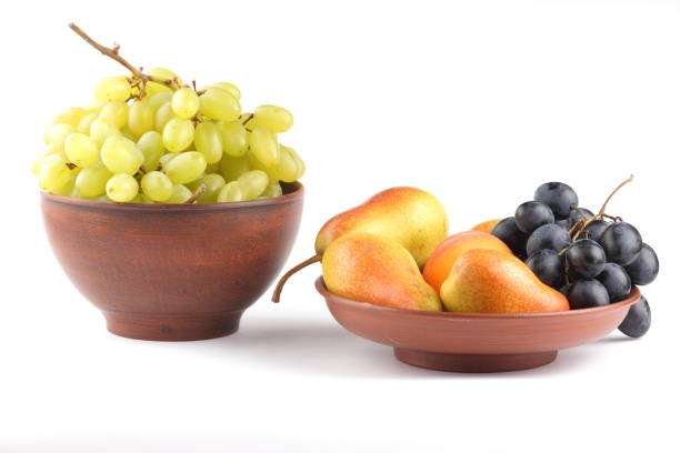 istock Yellow pears, green and blue grapes in a clay plate on a white background 856706972