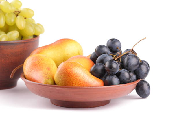istock Yellow pears, green and blue grapes in a clay plate on a white background 856707226