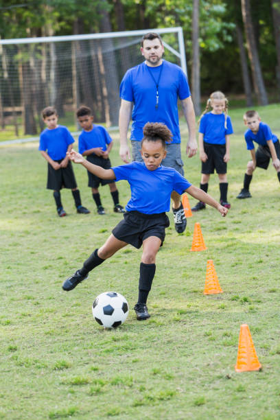 mädchen auf fußball team üben, trainer beobachten - soccer child coach childhood stock-fotos und bilder