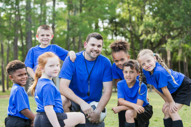 dziecięca drużyna piłkarska z trenerem - football child american football team zdjęcia i obrazy z banku zdjęć