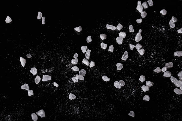 istock WHite salt on a black background. Aromatic, mineral salt condiment. Cooking concept. 856717838