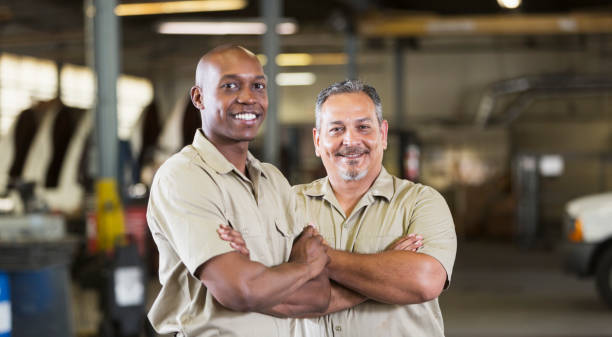 dois trabalhadores da empresa na garagem de caminhões - truck driver multi ethnic group industry working class - fotografias e filmes do acervo