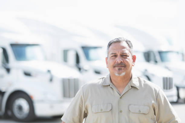 istock Hispanic man standing in front of semi-trucks 856729754