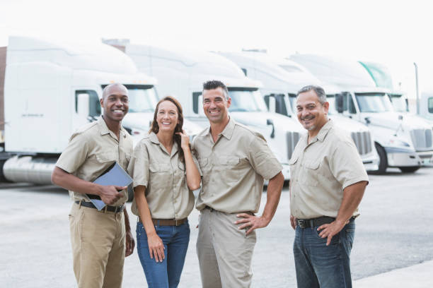 vier multi-ethnischen arbeiter vor sattelzügen - computer manual worker truck driver truck stock-fotos und bilder