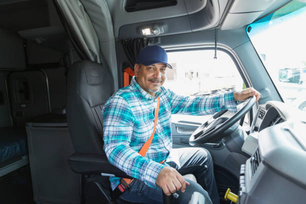 Hispanic man driving a semi-truck stock photo