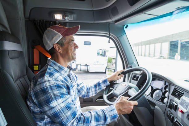 mature man driving a truck outside warehouse - distribution warehouse industrial building large building exterior imagens e fotografias de stock