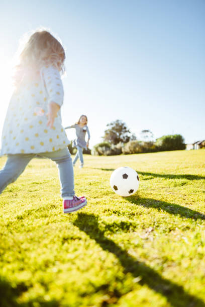 istock little girl playing with a soccer ball 856733786