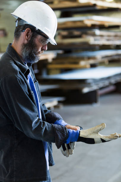 istock Worker in factory putting on gloves 856733860